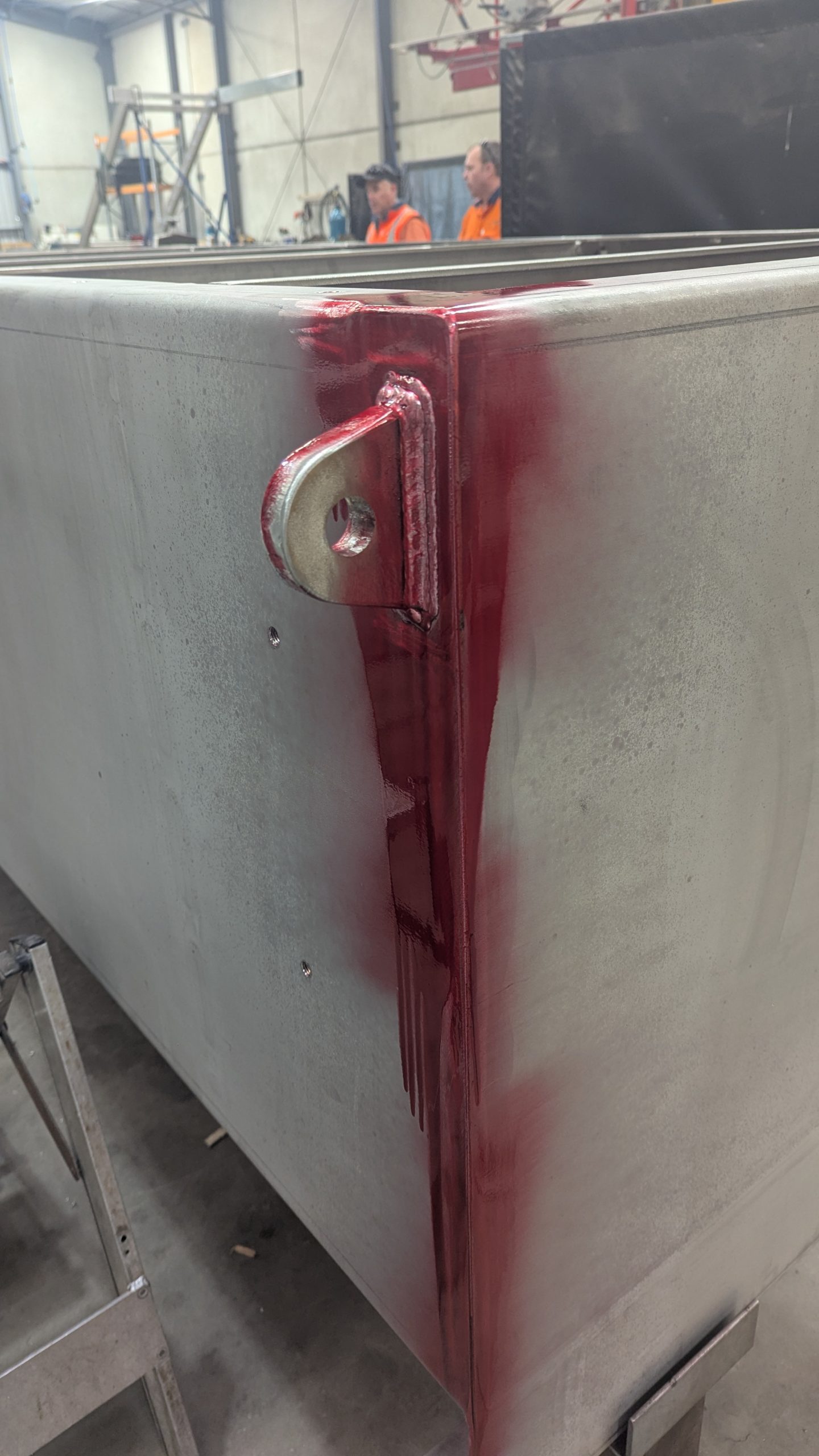 Dye penetrant applied to a welded joint on a stainless steel tank during non-destructive testing.